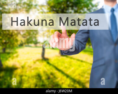 Hakuna Matata (Swahili phrase it means no worries)  - Businessman hand pressing button on touch screen interface. Business, technology, internet conce Stock Photo
