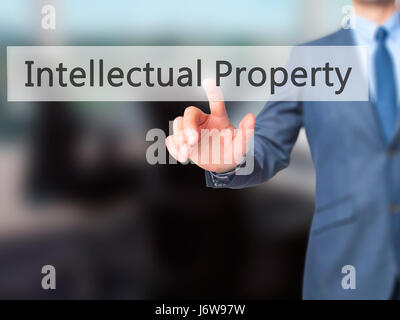 Intellectual Property - Businessman hand pressing button on touch screen interface. Business, technology, internet concept. Stock Photo Stock Photo