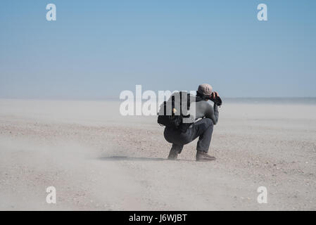 Man taking photos during  windy day on the beach Stock Photo