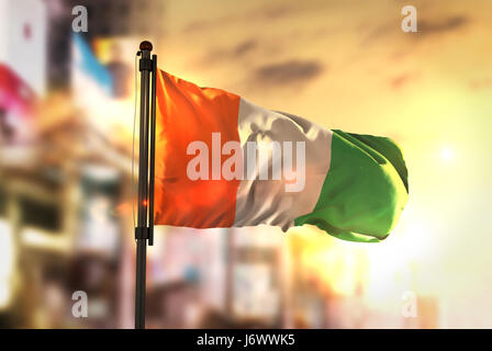 Ivory Coast Flag Against City Blurred Background At Sunrise Backlight Stock Photo