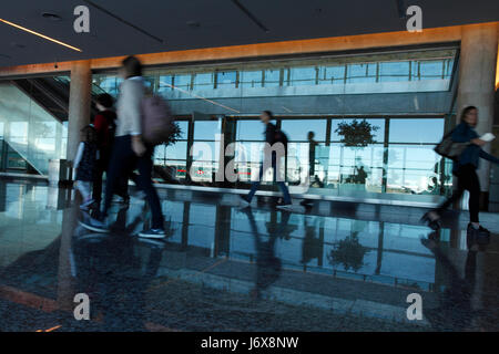 Passengers walking between gates at an international airport. Stock Photo