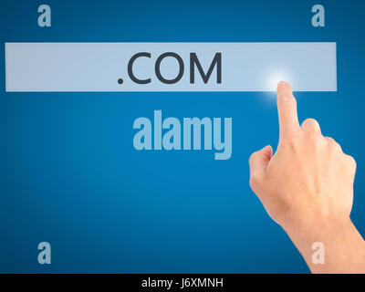 .COM - Hand pressing a button on blurred background concept . Business, technology, internet concept. Stock Photo Stock Photo