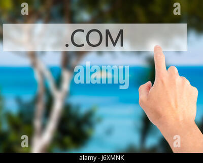 .COM - Hand pressing a button on blurred background concept . Business, technology, internet concept. Stock Photo Stock Photo