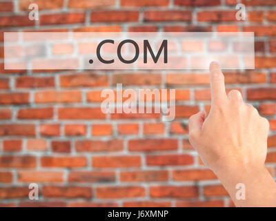 .COM - Hand pressing a button on blurred background concept . Business, technology, internet concept. Stock Photo Stock Photo