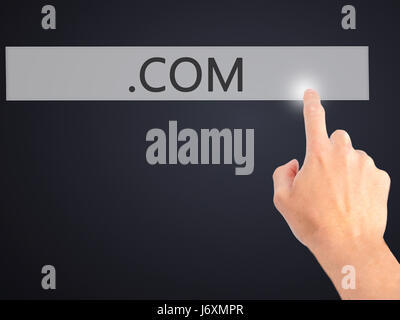 .COM - Hand pressing a button on blurred background concept . Business, technology, internet concept. Stock Photo Stock Photo