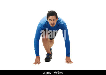 Young asian man on ready position to run isolated over white background Stock Photo