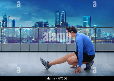 Portrait of asian man doing training before running workout at terrace gym Stock Photo