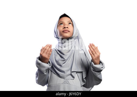 Little asian muslim girl praying to god isolated over white background Stock Photo
