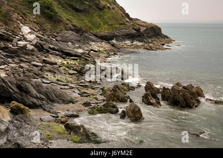 UK, Cornwall, St Austell, Polkerris, waves breaking on rocky shore Stock Photo