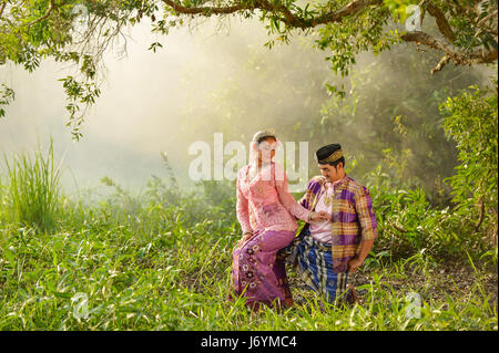 Asian couple wearing traditional dress  dancing in forest, Thailand Stock Photo