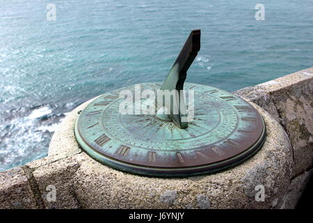 Antique sundial on a stone wall overlooking the sea Stock Photo