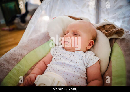 Baby boy sleeping in a baby bouncer Stock Photo