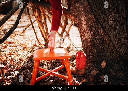 Boy climbing a tree barefoot Stock Photo