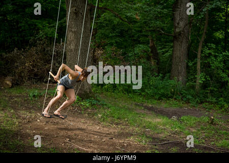 Woman on a swing in forest Stock Photo