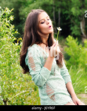 Girl blowing a dandelion clock Stock Photo