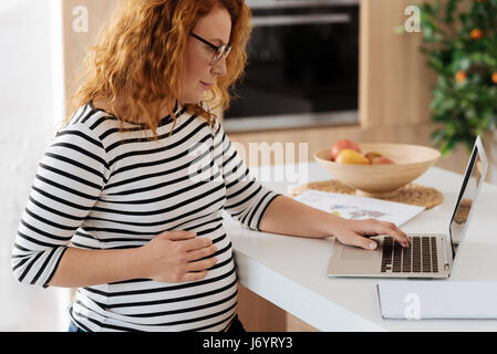 Curly-haired future mom working from home Stock Photo