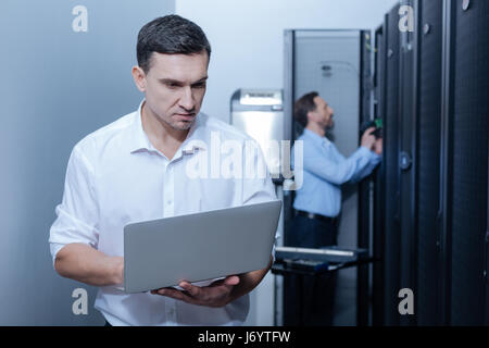 Pleasant young programmer using a laptop Stock Photo