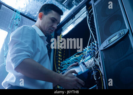 Handsome serious engineer working in the network server room Stock Photo