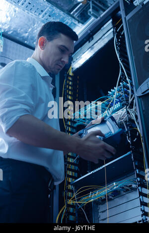 Serious male IT administrator working in the data center Stock Photo