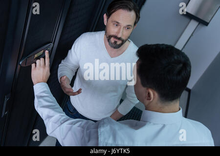 Handsome bearded man having a conversation with his colleague Stock Photo