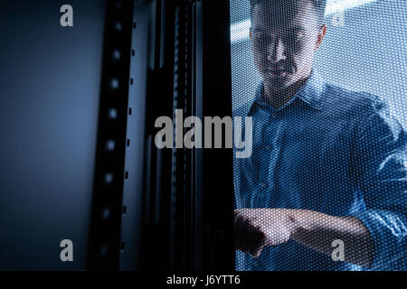 Serious young man working in the server room Stock Photo