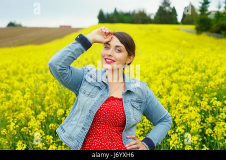 A portrait of woman in rapeseed field. Stock Photo