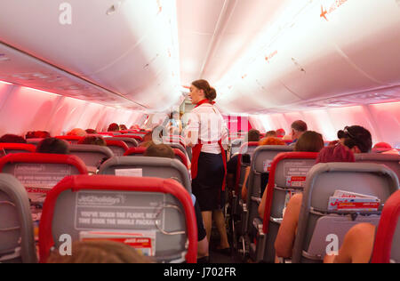Jet2 airline flight attendant working in the airplane cabin interior, on a Boeing 737-800 flight from Lanzarote to UK Stock Photo