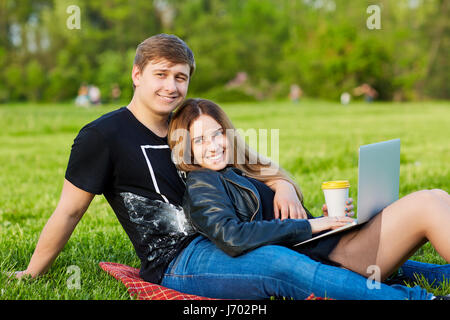 A loving couple with  laptop in the park Stock Photo