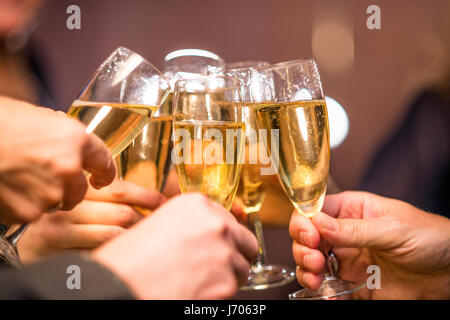 Group of people toasting with champagne glasses, celebrating together in a festive and joyful atmosphere. Stock Photo