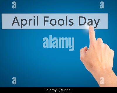 April Fools Day - Hand pressing a button on blurred background concept . Business, technology, internet concept. Stock Photo Stock Photo