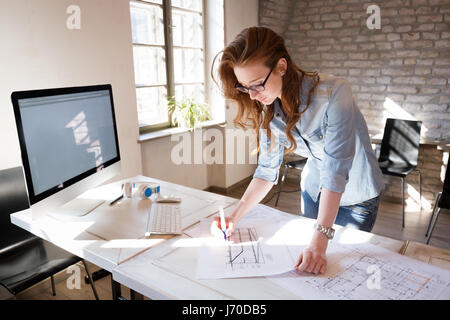 Female designer in office working on architects project Stock Photo