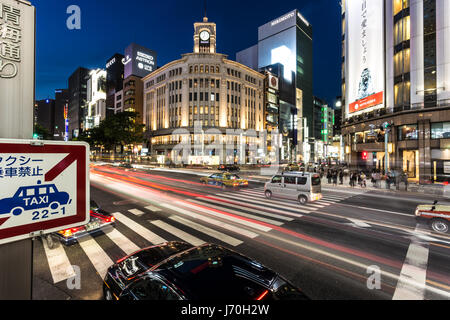 TOKYO - MAY 8, 2017: A bus rushes through an intersection in Ginza, the famous luxury shopping district in Tokyo at night in  Japan capital city. Stock Photo