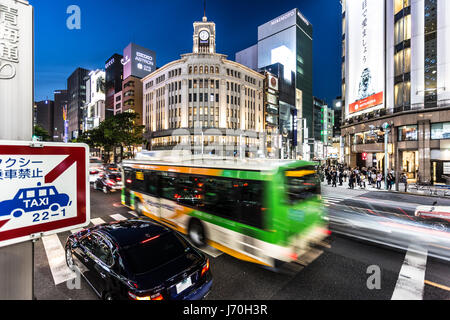 TOKYO - MAY 8, 2017: A bus rushes through an intersection in Ginza, the famous luxury shopping district in Tokyo at night in  Japan capital city. Stock Photo