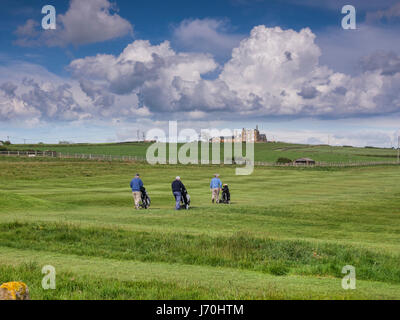 Golfers walking with trolleys on the course at Whitby Golf Club, North Yorkshire, England, UK Stock Photo