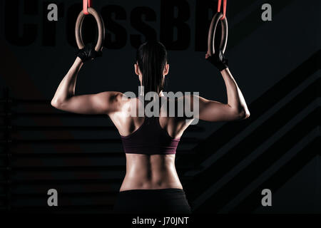 Sporty woman using gymnastic rings Stock Photo