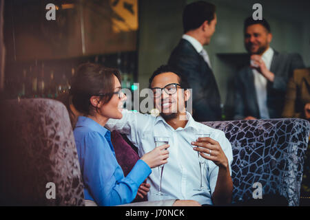 Couple enjoying a glass of champagne after work together at a bar. Stock Photo
