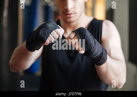Cropped image of boxer standing in gym. Focus on hands Stock Photo