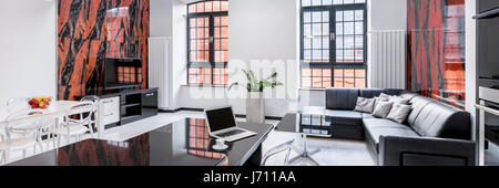 Modern designed living room and dining room with black and red wall tiles, panorama Stock Photo