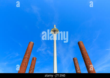 Brighton i360 observation tower on the seafront, with the rusty pier supports of the old West Pier in the foreground. Brighton, UK Stock Photo