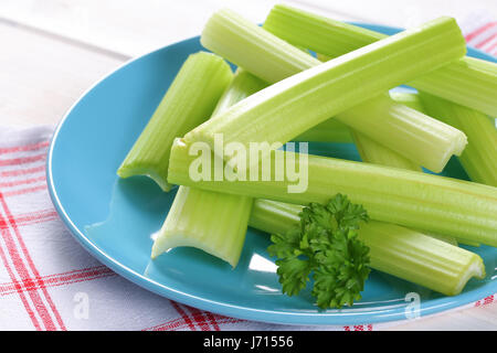 plate of green celery stems on checkered dishtowel - close up Stock Photo