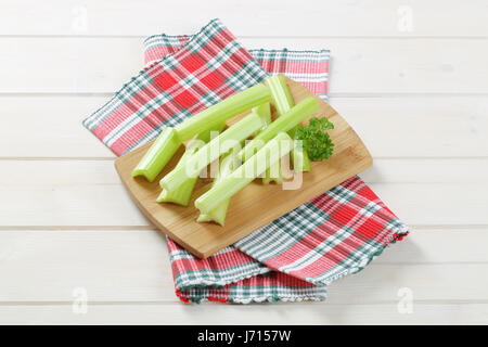 stems of green celery on wooden cutting board Stock Photo