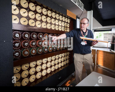 A docent explains a working recreation of the Turing Machine or Bombe at the home of the WWll codebreakers at Bletchley Park in England. Stock Photo