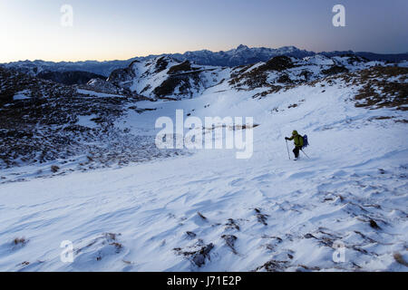 Woman hiking in the snowy mountains, Slatnik, Slovenia. Stock Photo