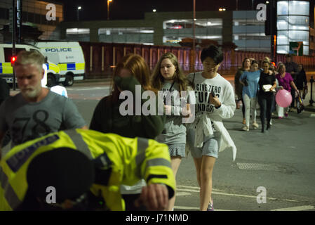 Manchester, UK. 23rd May, 2017. People, believed to be leaving the Manchester Arena, after an explosion after the Ariana Grande concert which took place on 05/22/2017 at Manchester Arena in Manchester, United Kingdom on Tuesday, May 23rd, 2017. Greater Manchester Police are treating this as terrorist incident. Credit: Jonathan Nicholson/Alamy Live News
