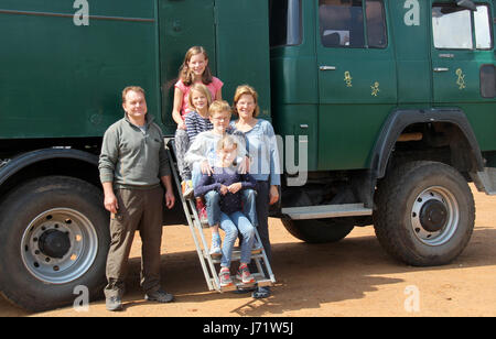 The Vosseberg family, photogrpahed in front of their truck 'Gruedi' in Johannesburg, South Africa, 26 April 2017. Father Jochen stands on the left, the children (bottom to top) Marie, Ruben, Lea and Hannah sit on the ladder while mother Judith stands on the right. Since August 2016, the Vosseberg fmaily has been touring from Oelde in North Rhine-Westphalia through Africa. Photo: Jürgen Bätz/dpa Stock Photo