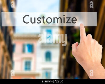 Customize - Hand pressing a button on blurred background concept . Business, technology, internet concept. Stock Photo Stock Photo