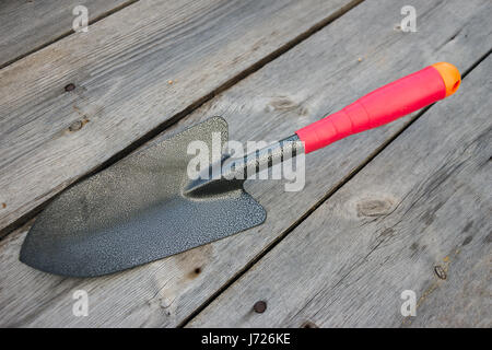 Small garden shovel on an old wooden background Stock Photo