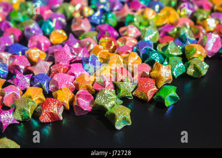 mass of colorful star paper on black floor Stock Photo