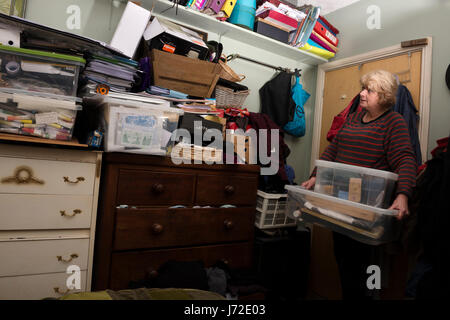 Woman with a cluttered bedroom Stock Photo