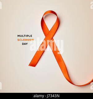 the text multiple sclerosis day and an orange ribbon on a beige background Stock Photo